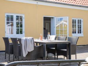 a dining table and chairs on a patio at Apartment Viivi - 900m from the sea by Interhome in Skagen +19 photos