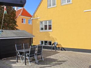 a table and chairs in front of a yellow building at Holiday Home Borka - 150m from the sea by Interhome in Skagen