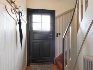 a black door in a hallway with an umbrella at Holiday Home Borka - 150m from the sea by Interhome in Skagen +16 photos