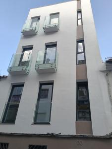 ein weißes Gebäude mit Seitenfenstern in der Unterkunft WOWHOLIDAYS Exclusive Building Center Ronda in Ronda