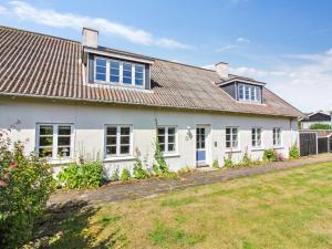 a white house with a brown roof and a yard at Apartment Anais - 1-6km from the sea by Interhome in Skagen