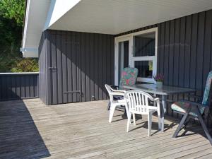 un patio con tavolo e sedie su un ponte di Holiday Home Igilfar - 700m from the sea by Interhome a Vejers Strand