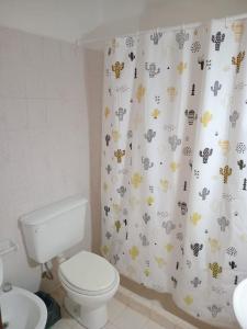 a bathroom with a toilet and a shower curtain with animals at Departamentos Perla del mar in Las Grutas