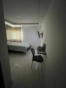ein Schlafzimmer mit einem Stuhl und einem Bett in einem Zimmer in der Unterkunft AP Ribeiro in Cruz das Almas
