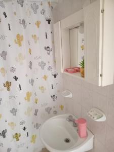a bathroom with a sink and a shower curtain with hearts at Departamentos Perla del mar in Las Grutas