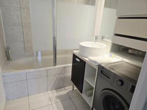 y baño con ducha y lavadora. en Rob’s Place - Paris Convention Center, en Vanves