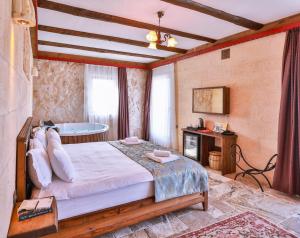 a bedroom with a bed and a bath tub at Noble Crown Stone House Cappadocia in Uchisar