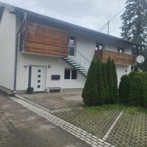 a white house with a balcony and a staircase at Gemütliche Wohnung in St Georgen nähe Attersee in Vöcklabruck