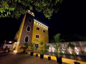 KuilapayamにあるSavera Beach walk Stayの夜時計塔のある黄色い建物