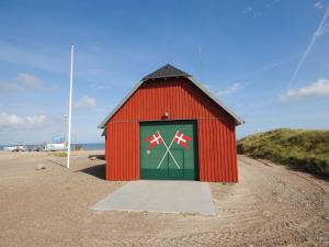 a red building with a door on the beach at Holiday Home Tamika - 950m from the sea by Interhome in Fjerritslev