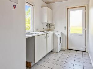 a white kitchen with a sink and a washing machine at Holiday Home Aku - 24km from the sea by Interhome in Højer