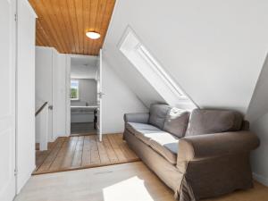 Una sala de estar con un sofá y una escalera. en Apartment Angelie - 350m from the sea by Interhome, en Neksø