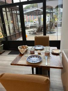 a wooden table with plates of food on it at Les Terrasses de Sax in Dinant