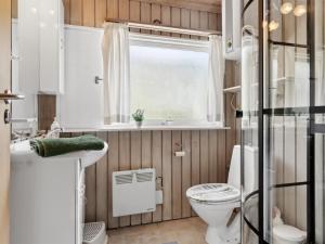 a small bathroom with a toilet and a window at Holiday Home Zoya - 470m from the sea by Interhome in Gedser