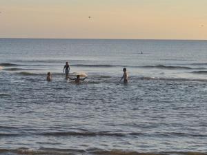 a group of people in the water at the beach at Apartment Werna - 800m from the sea by Interhome in Bjerregård