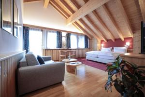a living room with a bed and a couch in a room at Hotel Sonnenhalde, Arosa in Arosa