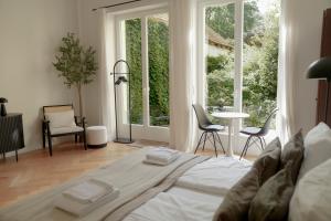 a bedroom with a large bed with chairs and windows at Design Apartment with Garden in Berlin