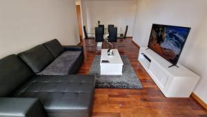 a living room with a couch and a flat screen tv at Casa Nobrega in Caniço