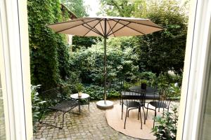 ベルリンにあるDesign Apartment with Gardenのテーブルと椅子と傘のあるパティオ +48枚の写真