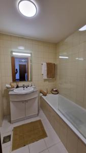 a bathroom with a sink and a bath tub and a mirror at Casa Nobrega in Caniço +7 photos