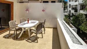 einen weißen Tisch und Stühle auf einer Terrasse in der Unterkunft Garden City in Playa Fañabe