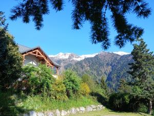 a house on a hill with mountains in the background at Auberge le Chaudron in Montsapey