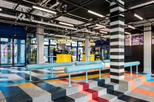 a lobby with blue benches on a colorful floor at The Social Hub Berlin Alexanderplatz in Berlin