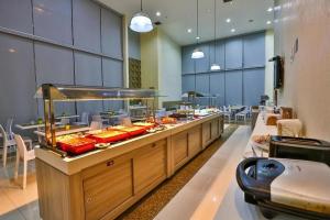 a buffet line in a restaurant with a lot of food at Flat Particular Hotel Confort Taguatinga in Taguatinga