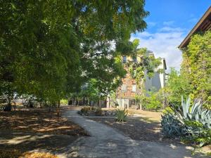 a walkway in a park with trees and a building at Appartement haut de gamme proche des plages in Saint-Paul