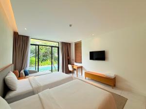 Una habitación de hotel con dos camas y un televisor. en Luxury 3BR BeachFront, en Cam Lâm 100 fotos más