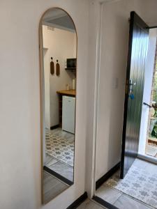 a mirror on a wall next to a kitchen at Petite Vine in Stellenbosch