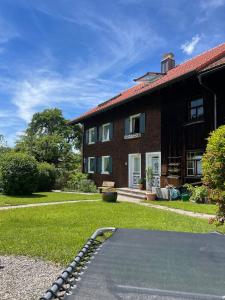 a house with a skateboard in front of a yard at Uriges Haus im Grünen in Grünenbach