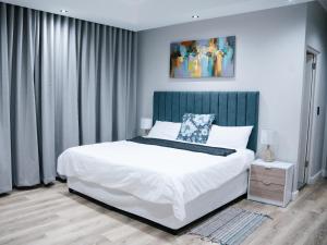 1 dormitorio con cama blanca y cabecero azul en Bokwe Guesthouse - Gordons Bay, en Gordonʼs Bay 45 fotos más