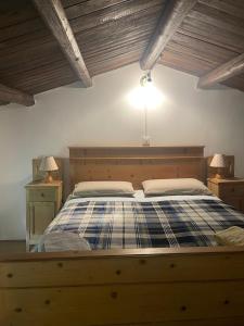 a bedroom with a wooden bed with two night stands at ALTRAVISTA TARZO in Revine Lago