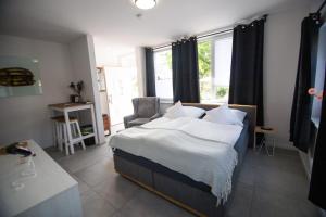 a bedroom with a bed and a chair and window at FEWOHOME Lothe Schieder Schwalenberg Schiedersee in Schieder-Schwalenberg