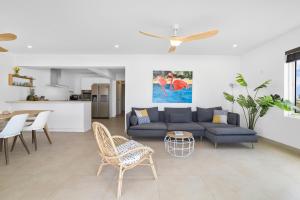 a living room with a couch and a table and chairs at Playa Breeze Apartment in Kralendijk