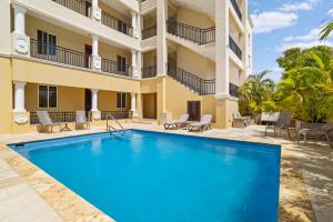 a swimming pool in front of a building at Playa Breeze Apartment in Kralendijk
