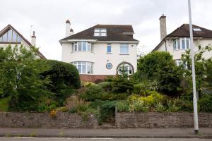 a white house with a garden in front of it at Valley House in Exeter