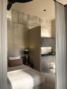 a bedroom with a bed and a kitchen at SUITES 9 MALAGA, three unique suites with private plunge pool in Málaga