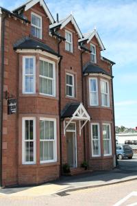 a red brick building with white windows at Ashberry Guest House in Penrith