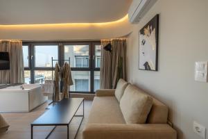 a living room with a couch and a large window at MeTHEA in Thessaloniki