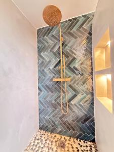 a shower in a bathroom with a tile wall at Casa Espeñuela in Ojén
