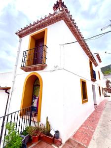 a white house with a window and a balcony at Casa Espeñuela in Ojén