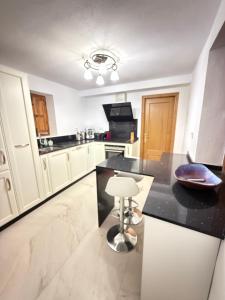 a kitchen with white cabinets and a black counter top at Casa Espeñuela in Ojén