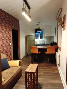 a kitchen and living room with a couch and a table at La Petite Fabrique in Villedieu-sur-Indre