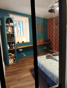 a bedroom with a bed in a room with green walls at La Petite Fabrique in Villedieu-sur-Indre +2 photos