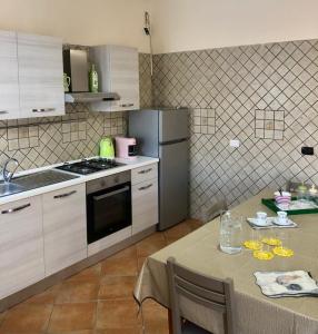 a kitchen with a table and a refrigerator at BeB Lucky House Francesca in Scafati