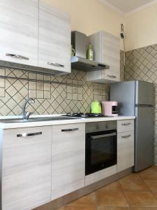 a kitchen with white cabinets and a stainless steel refrigerator at BeB Lucky House Francesca in Scafati +19 photos