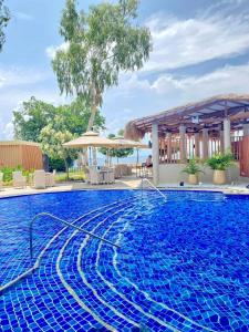 a large blue swimming pool with an umbrella at MACTAN NEWTOWN FAMILY ROOM Deluxe with free wi-fi, POOL & GYM in Lapu Lapu City