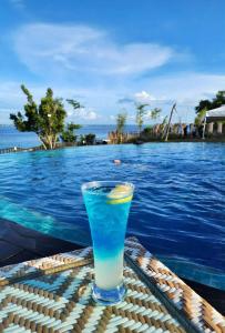 a drink sitting on a table next to a swimming pool at MACTAN NEWTOWN FAMILY ROOM Deluxe with free wi-fi, POOL & GYM in Lapu Lapu City +25 photos